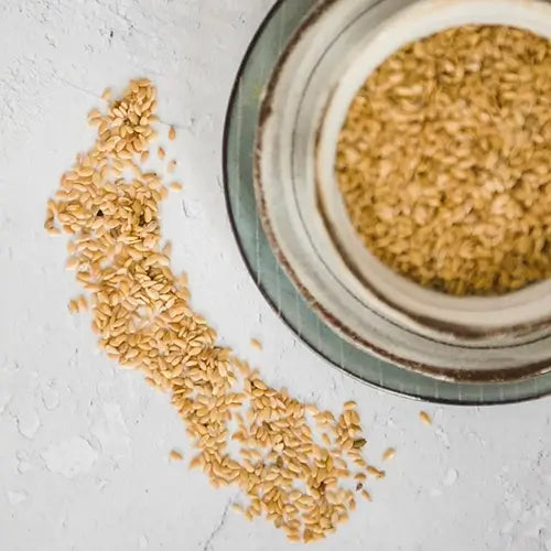 Golden Linseed (flax) sprinkled on a work surface.