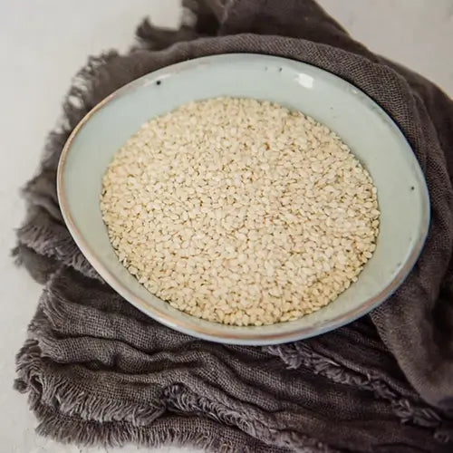 Bowl of sesame seeds sitting on grey tea towel