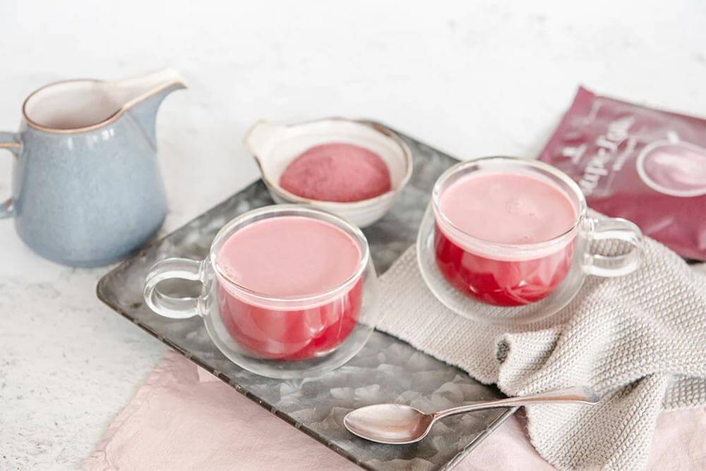 2 glass mugs of Purition's Beetroot Super Latte served up on a tray ready to enjoy!