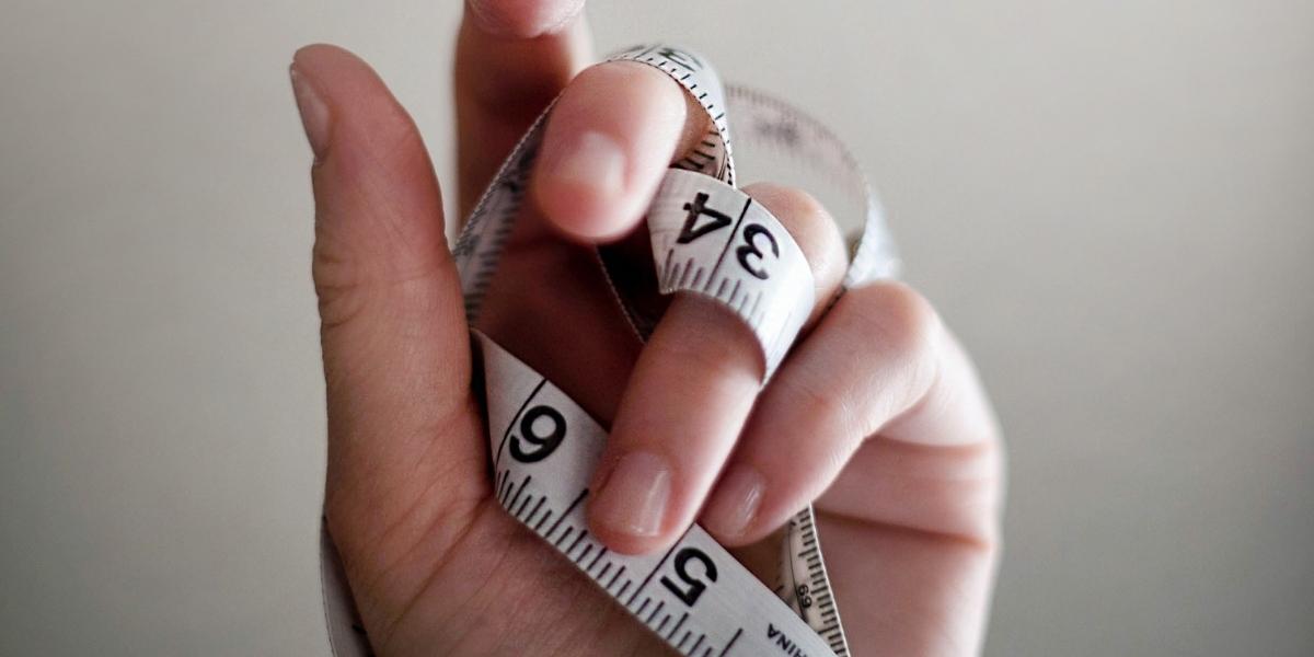 Hand holding a tape measure.