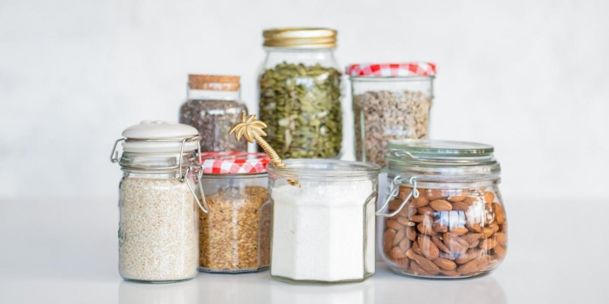 In the kitchen; A group of 7 glass jars containing all the seeds and nuts used to make Purition: sesame seeds, flaxseed, coconut, pumpkin seeds, chia seeds, almonds & sunflower kernels.