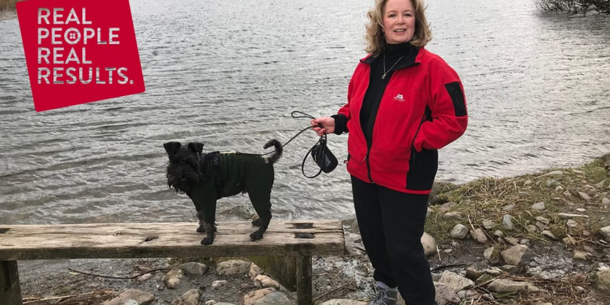 Jane Saxon in red jacket with dog by lake