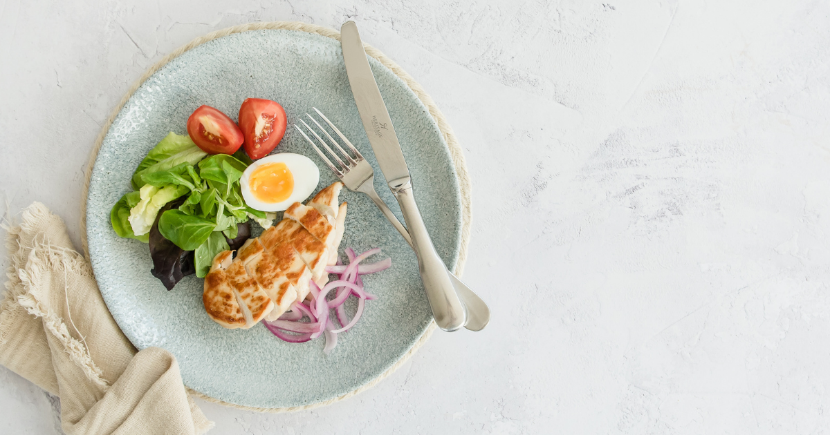 Grilled chicken breast with a clean and colourful mixed salad with half a soft boiled egg.