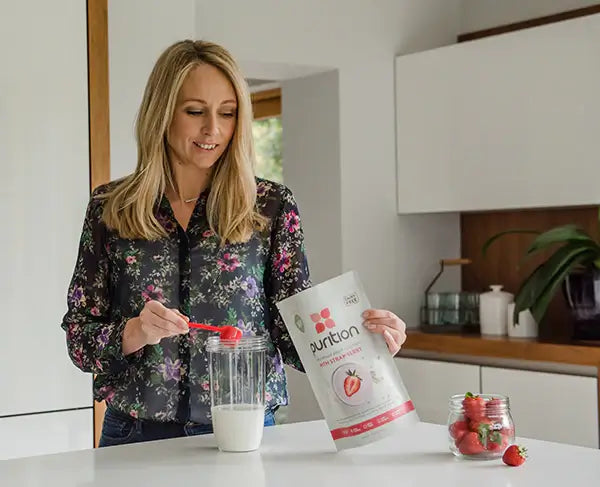 Person in kitchen preparing a Purition whole food meal shake that's suitable for fasting, IF, 5:2, 16/8.