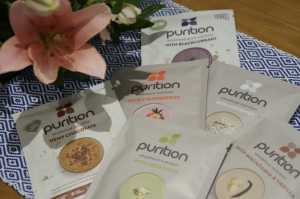 Pile of Purition protein powder sachets