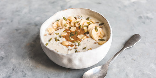 Healthy vegan yoghurt bowl with banana, nut butter & seeds