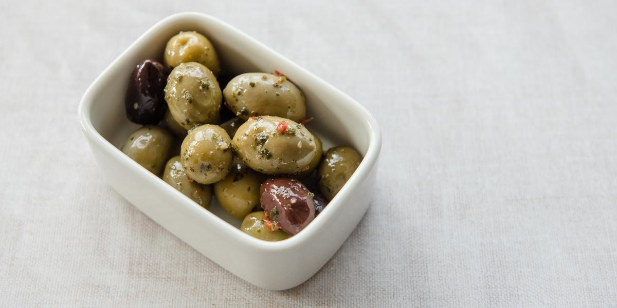Small white rectangular bowl of mixed olives