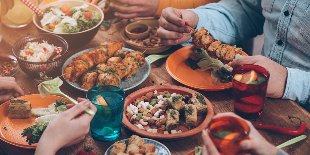 Table full of plates with food, including tikka kebabs