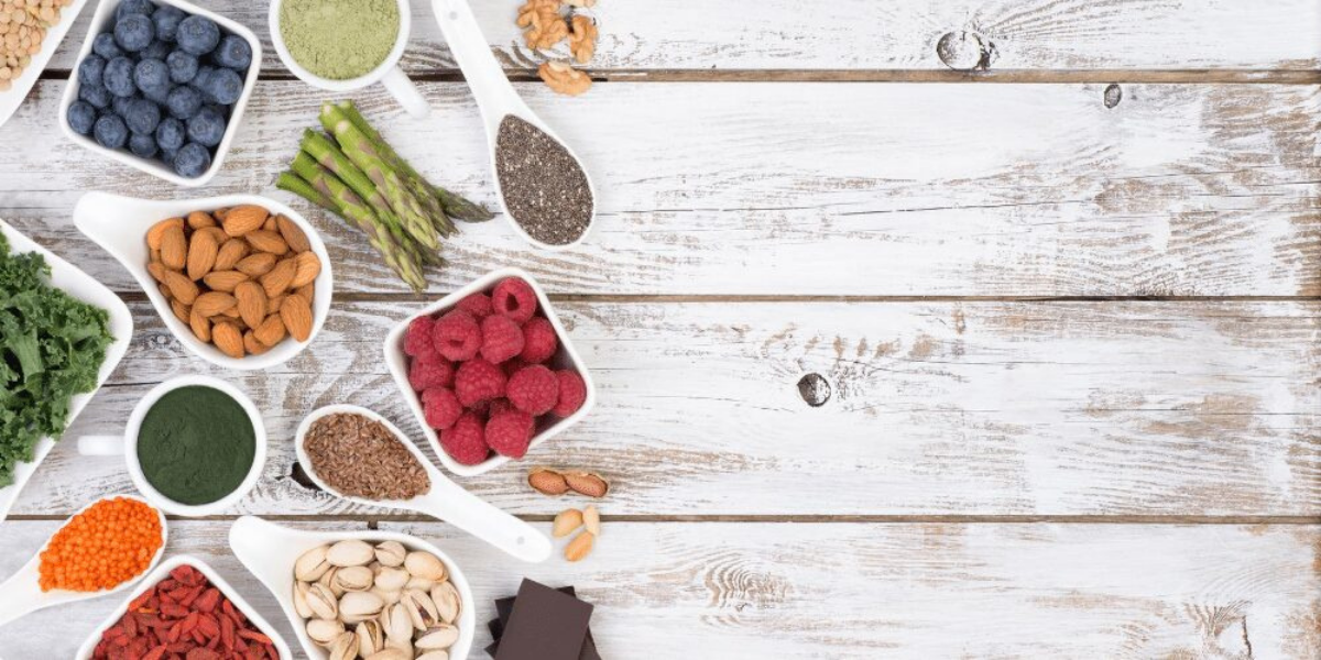 Bowls of nuts, fruit and seeds on wooden floor