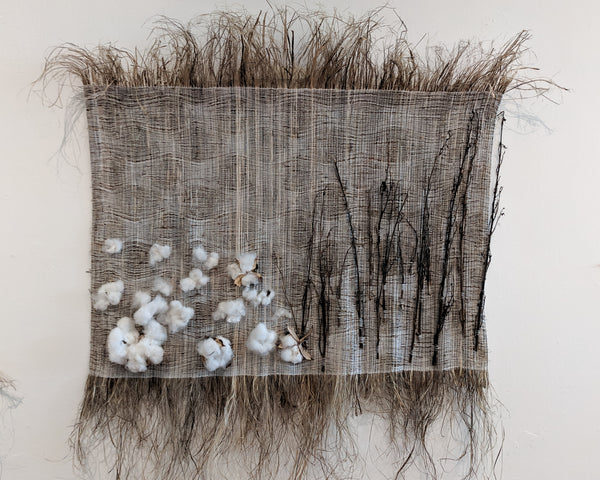 An abstract landscape made of grassy textured fibers (raw hemp). Embroidered on the surface are natural cotton balls and hemp twigs.