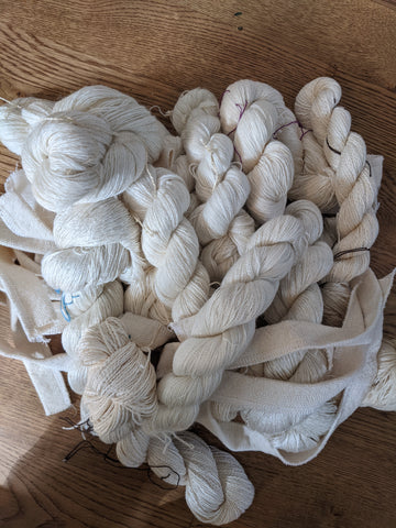 pile of skeins of undyed yarn. 