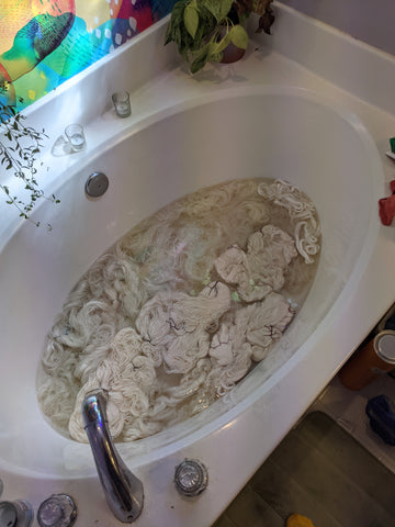 a bathtub full of wet yarn in beige colored water.