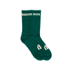 A pair of green & cream colored Shopify Supply Business as Usual Socks with a cream Shopify logo on the top of the foot.