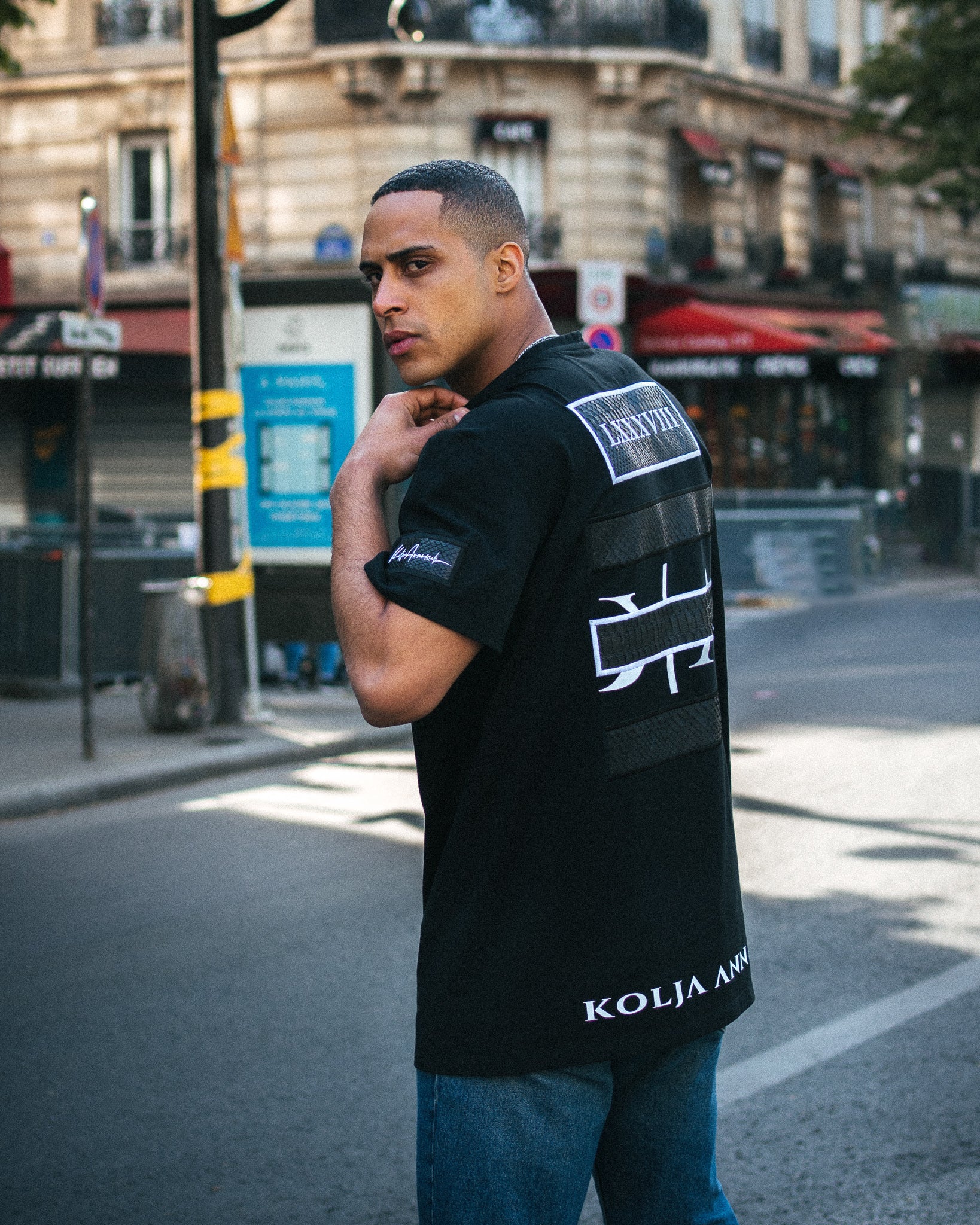 Fashion Model David Koya wearing black designer T-Shirt by Kolja Annussek in Paris.