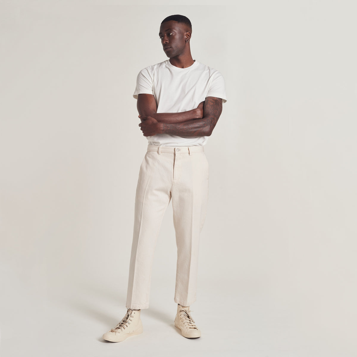black man wearing a plain white t shirt and cropped creased pants fro YONY
