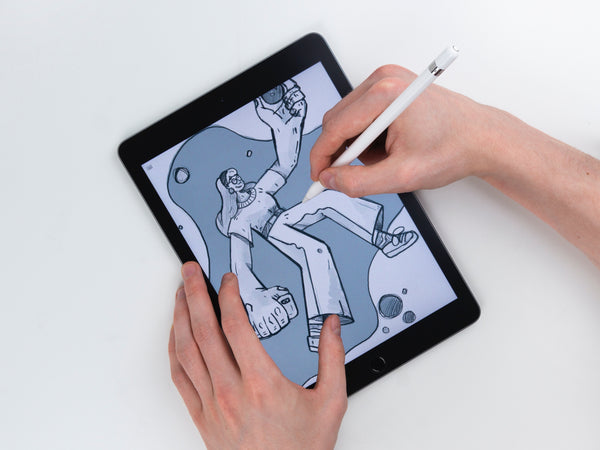 A hand using the pen on a tablet to create art and draw.