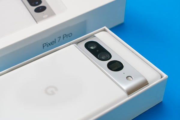 A white Google Pixel 7 Pro face down in the box with a blue background.