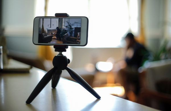 A Google Pixel phone set up on a tripod filming a man in a loungeroom.