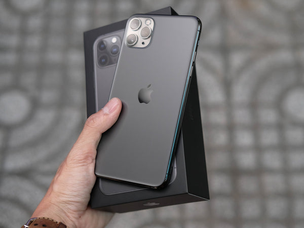 Hand holding a black iPhone 11 pro and box