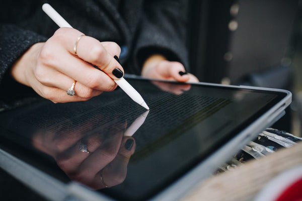 Woman highlighting text on an iPad using a stylus pen