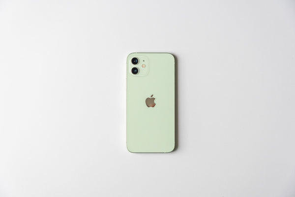 Mint green iPhone 12 laying flat on white surface