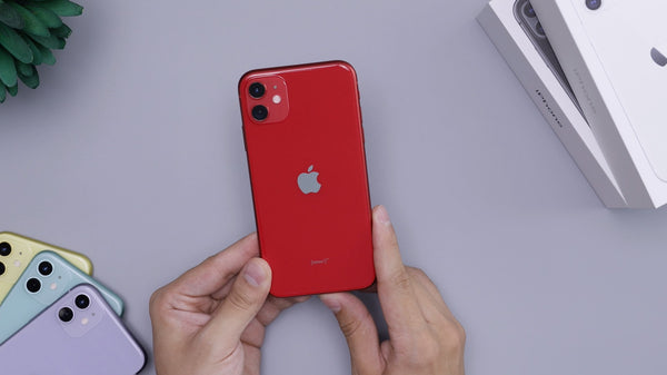 Red iPhone 11 held next to purple, blue and yellow iPhone 11
