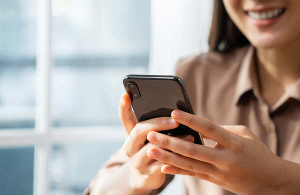 A woman smiling at her smrtphone