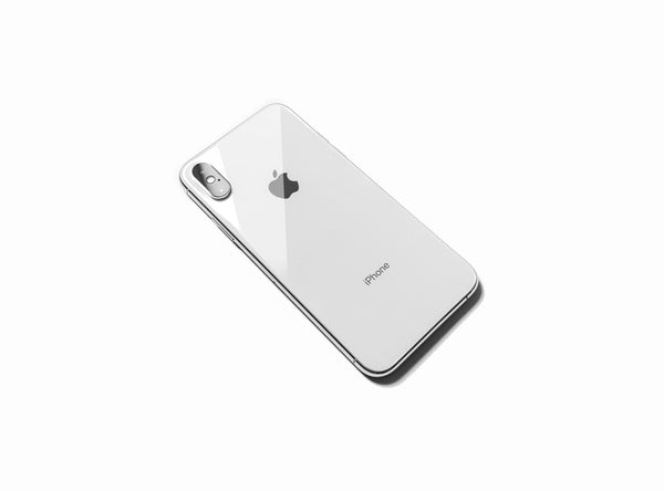 White iPhone X laying flat showing the apple on the back