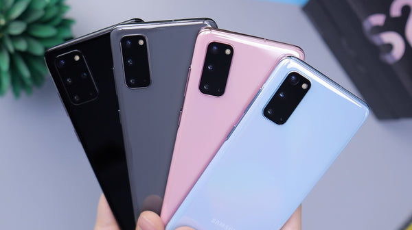Four smartphones in different colours fanned out in a person hand