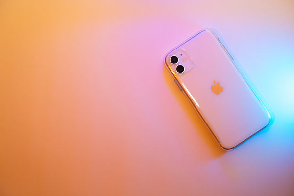 An iPhone with a peachy pink and orange background