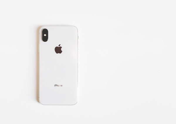 White iPhone X laying face down on a white surface