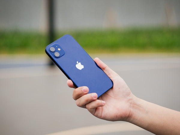Hand holding dark blue iPhone 12