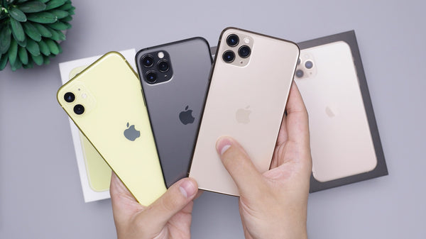 Three different coloured iPhones fanned out and held in two hands