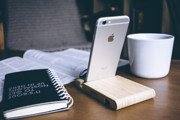 iPhone standing up in front of an open book and coffee mug