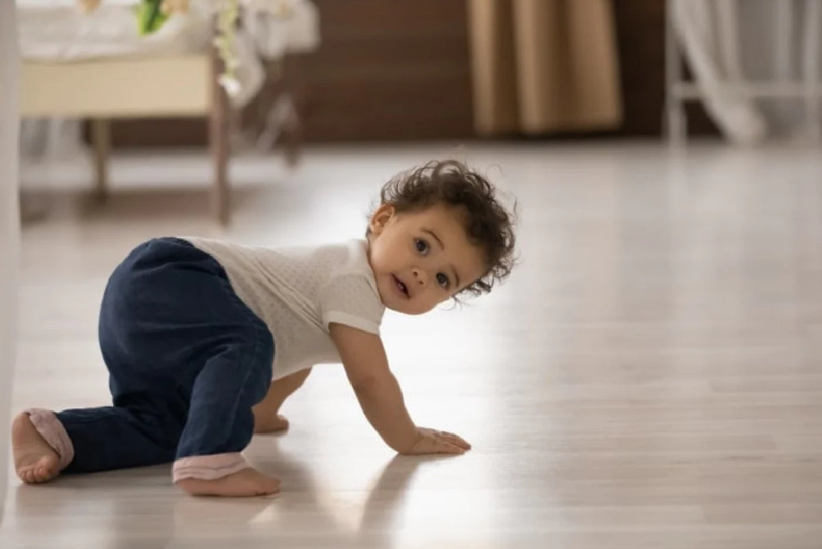 Baby learning to crawl on floor