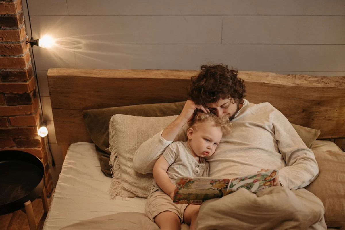 dad reading to toddler in bed