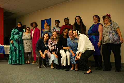 Our team of staff, volunteers, teachers, and students poses in front of our "EcoEquitable" banner.