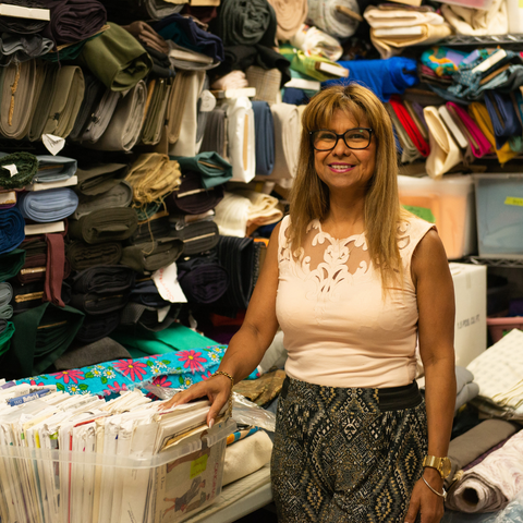 Our Eco Fabric Boutique manager, Carolin, poses in front of our collection of fabric and notions!