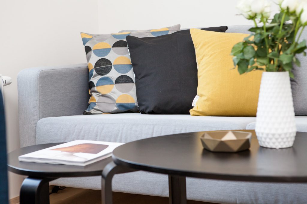 three accent pillows on a gray sofa for staging