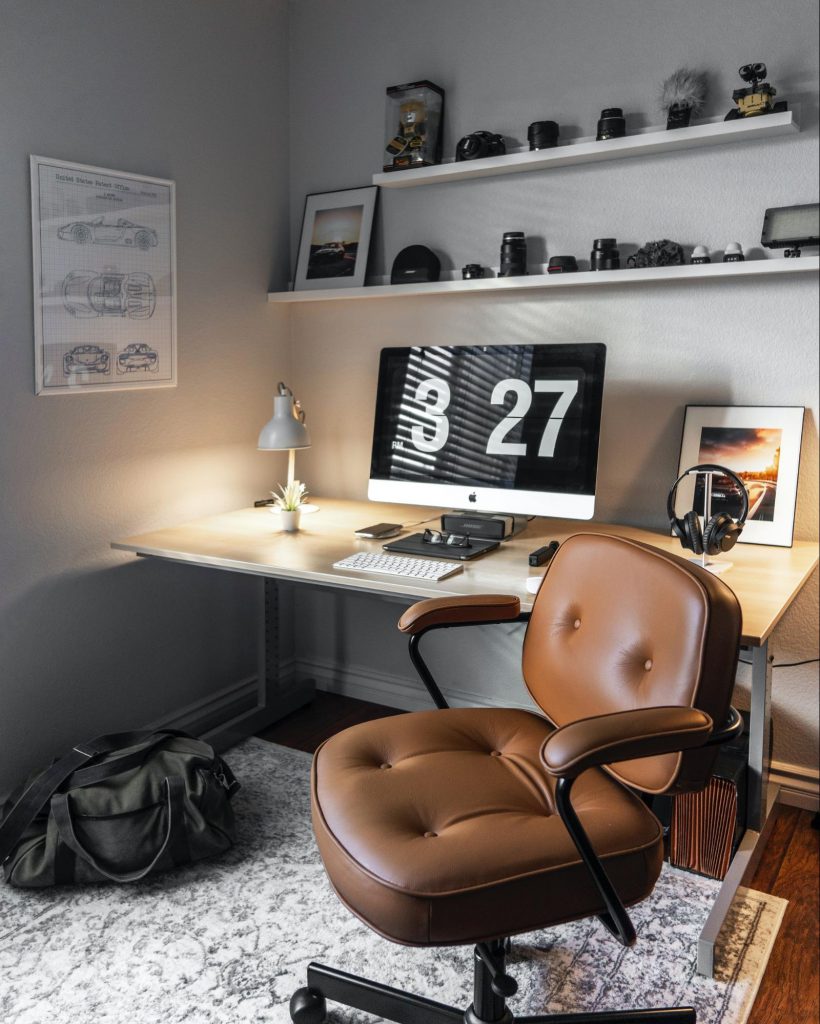 Pattern rug under brown chair and wooden table in a modern home office design.