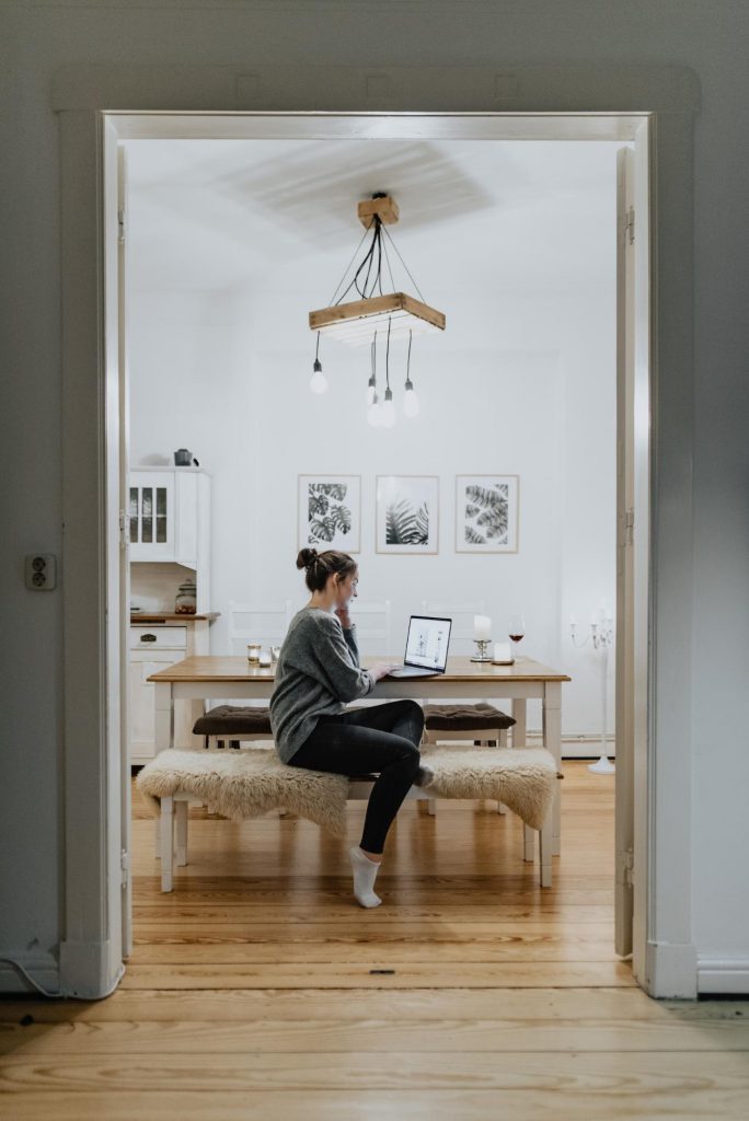 Woman using dining table as a temporary home office