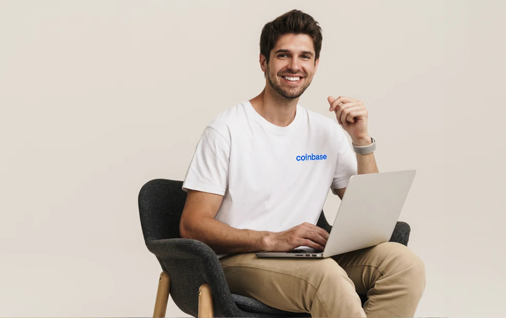 A male employee smiling and working on laptop
