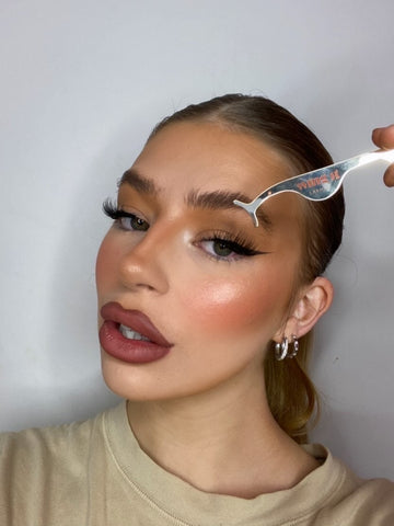 Woman applying false lashes on top of adhesive eyeliner