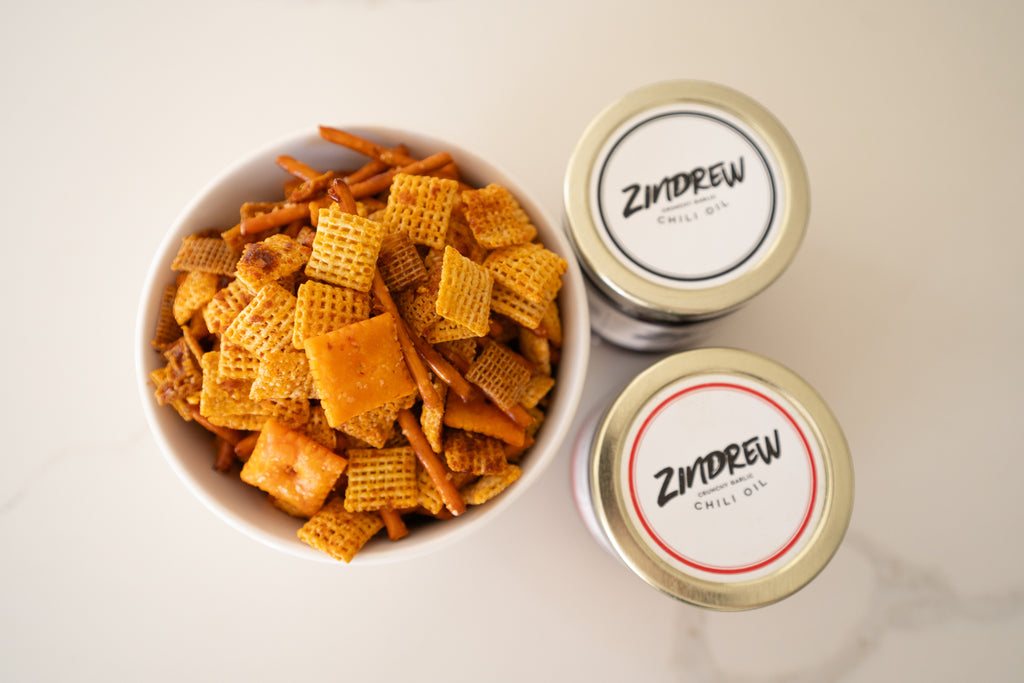 zindrew chex mix in a bowl next to jars of zindrew