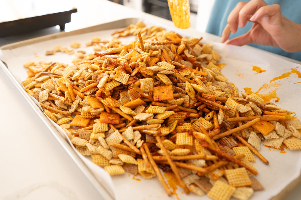 mixing chex mixture with zindrew and butter sauce