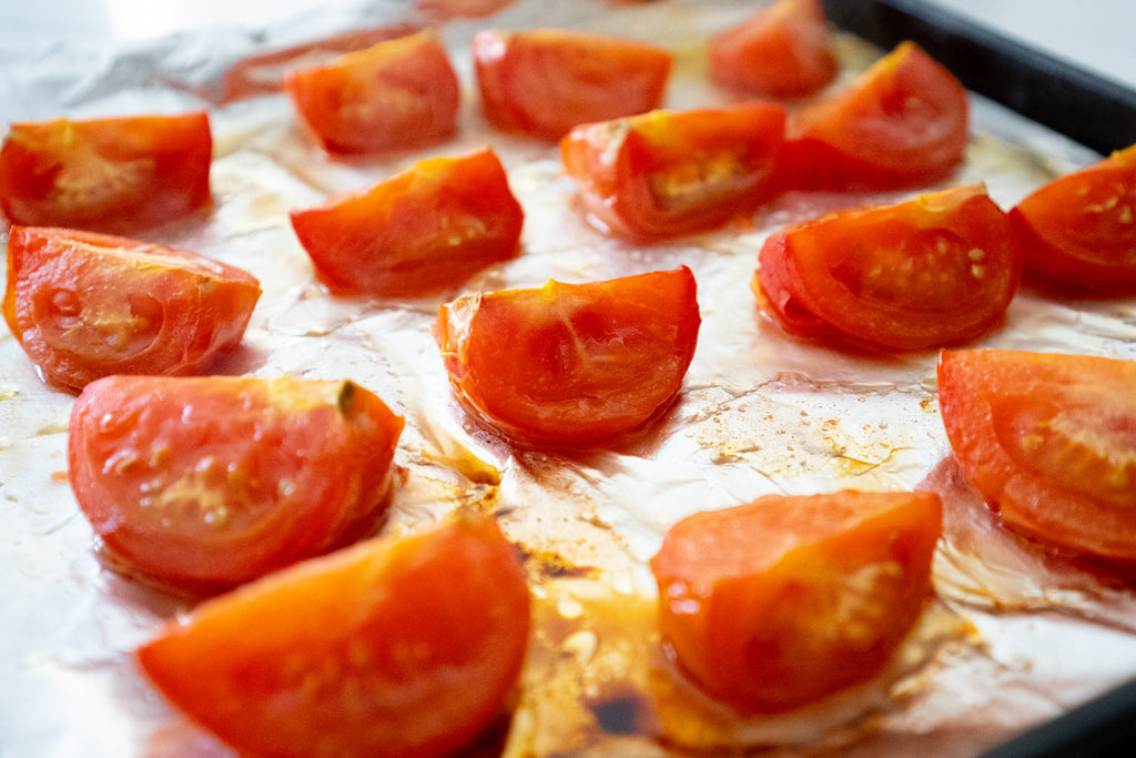 tomatoes roasting on a sheet pan