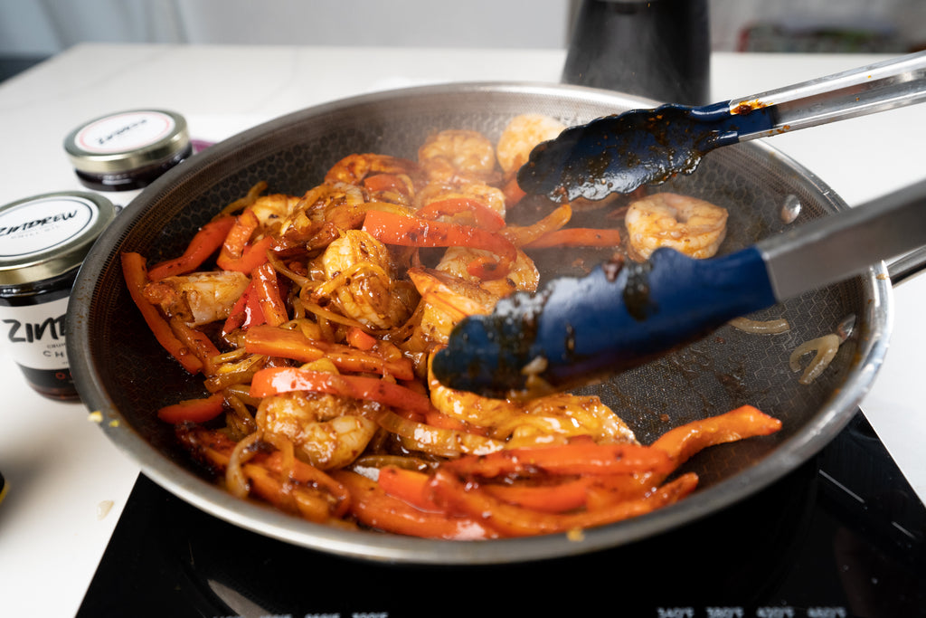 shrimp, bell peppers, and onions in a pan cooking