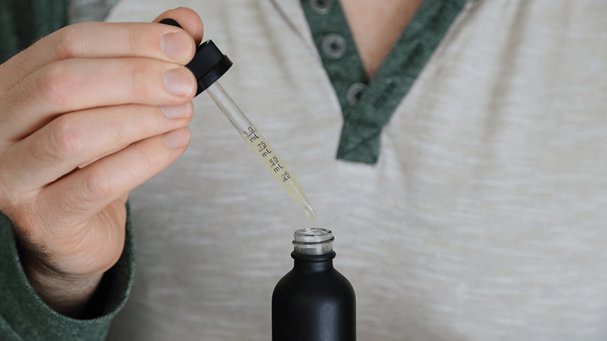 hands opening tincture bottle 