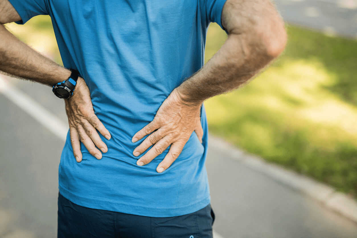 person resting their hands on their lower back 