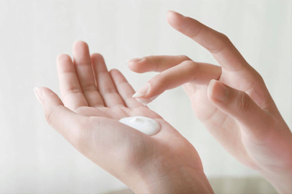 hands with white moisturizer 